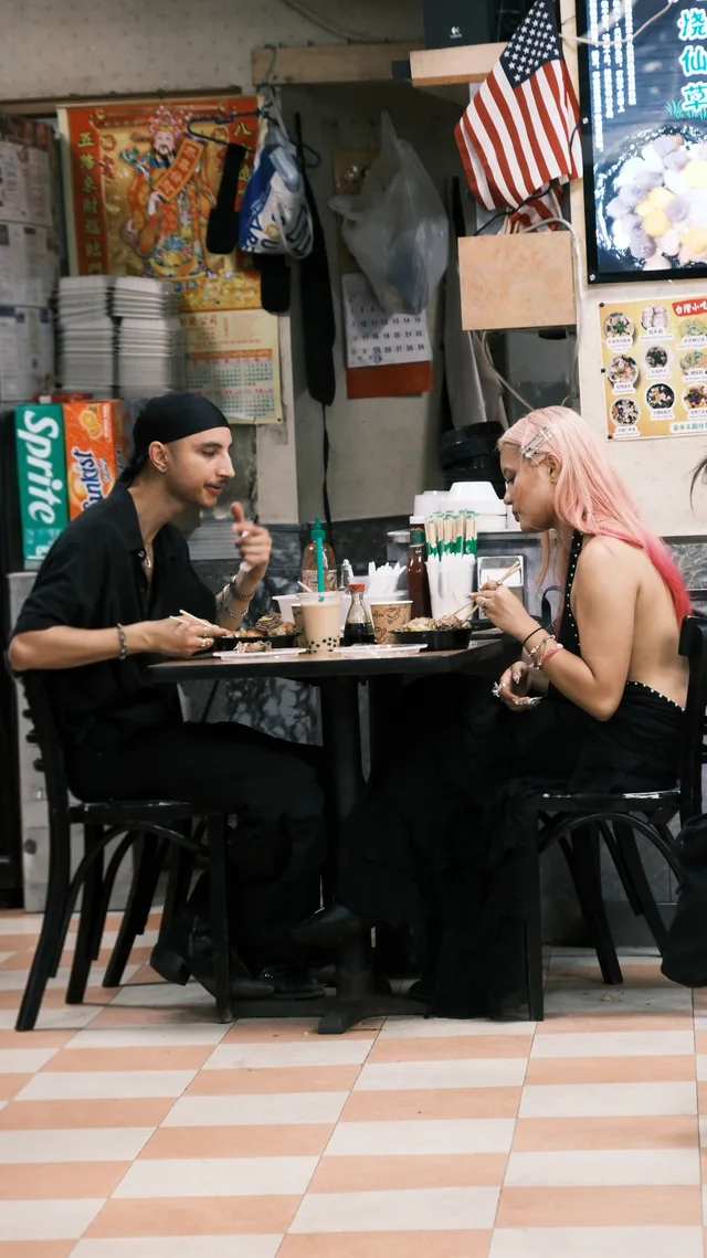 Two diners face each other at a small restaurant table.
